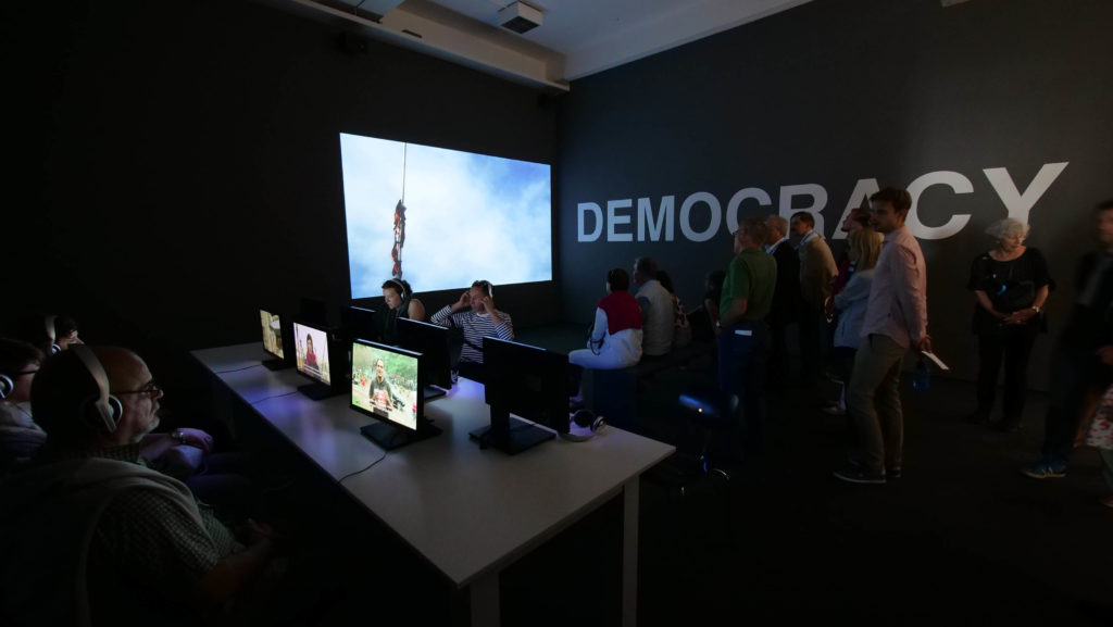 Oliver Ressler, “What Is Democracy?”, 8-channel video installation, 2009 (Installation view: “Antidoron – The EMST Collection”, Documenta 14, Kassel, 2017; photo: O. Ressler)